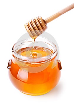 Glass jar of honey with wooden drizzler photo