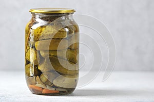 Glass jar with an iron lid with canned cucumbers