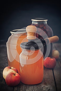 Glass jar of juice, apples and can lid closing machine for canning.