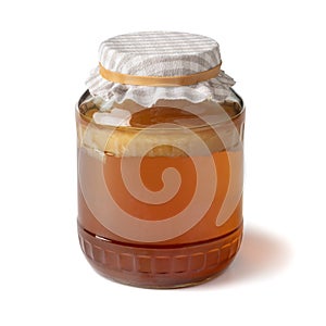 Glass jar with a Kombucha tea mushroom, scoby to produce Kombucha drink isolated on white background