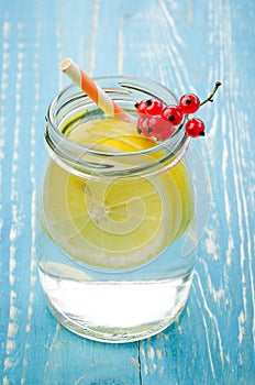 glass jar of lemonade with a lemon and red berries/glass jar of