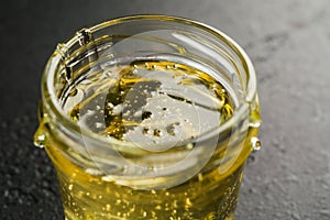 Glass jar with light sweet flower honey. Closeup view. Macro. Selective focus