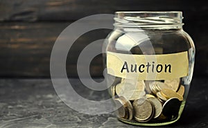 Glass jar with money and the inscription `Auction`. Public sales, property of enterprises, bargaining. Organization of auction tra