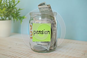 Glass jar with with money inside with word PENSION