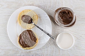 Glass jar with nut-chocolate paste, bread, teaspoon and sandwich