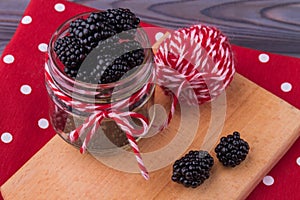 Glass jar overfilled with blackberries.