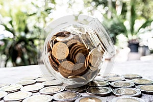 Glass jar piggy bank with coins. Plan your savings, run a growing business for success and save for retirement