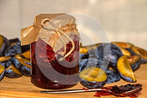 Glass jar with plum jam homemade and fresh plums