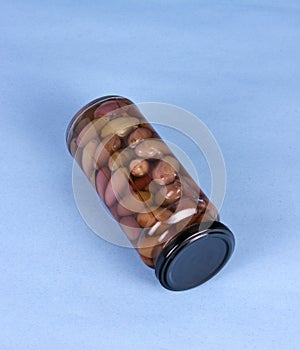 Glass jar of preserved olives laying