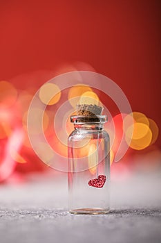 Glass jar and red heart on red background. Concept of love in Valentine`s Day