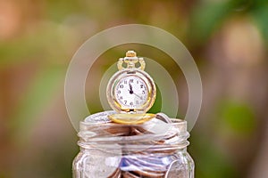 Glass jar with retro clock for time to money saving for retirement concept