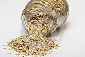 Glass jar with rolled oats isolated on white background