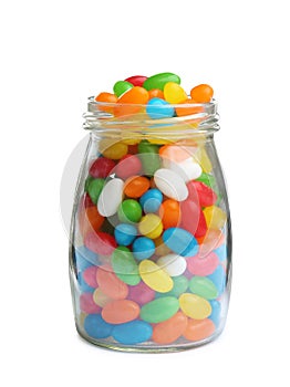 Glass jar of tasty jelly beans on background