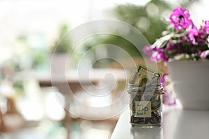 Glass jar with tips on table indoors. Space for text