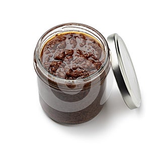 Glass jar with traditional homemade black olive tapenade close up on white background photo