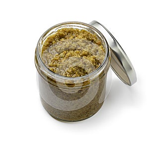Glass jar with traditional homemade green olive tapenade close up on white background photo