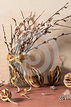 Glass jar with willow branches on rustic background. Easter season