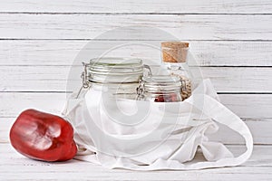 Glass jar, wooden brush and shopping bag on a white background. Zero waste concept. Kitchen background with no plastic utensils