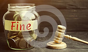Glass jar with the word Fine and the judge`s hammer. Penalty as a punishment for a crime and offense. Financial punishment.