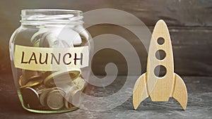 Glass jar with the word launch and rocket. The concept of raising funds for a startup. Charitable contributions to translate ideas