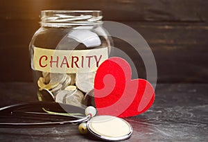 Glass jar with the words Charity and the heart. The concept of accumulating money for donations. Saving. Social medical help from