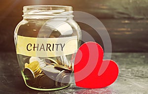 Glass jar with the words Charity and the heart. The concept of accumulating money for donations. Saving. Social medical help from