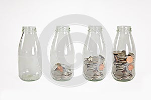 Glass jars with coins like diagram, isolated - savings concept
