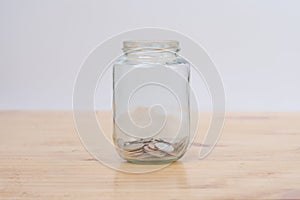 Glass jars with coins on wooden desk. Savings and Investments concept