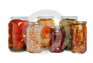 Glass jars of different pickled vegetables isolated