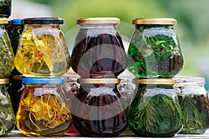 glass jars with favoured honey - with linden, herbs and pine needles, close-up