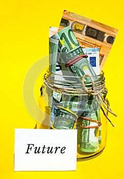 Glass jars filled with Euro bills, savings inside glass jar, money isolated on yellow background. Paper note written