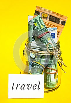Glass jars filled with Euro bills, savings inside glass jar, money isolated on yellow background. Paper note written
