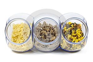 Glass Jars Filled with Various Shapes of Macaroni on White Background