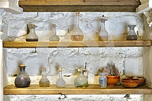 Glass jars and flasks of different colors and shapes in a very old pharmacy