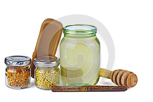 Glass jars with honey, pollen, brick of beeswax and stick of propolis
