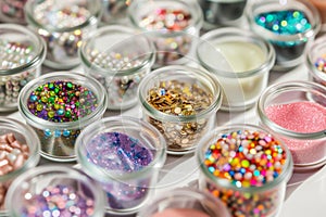 glass jars of nail embellishments on a manicure table photo