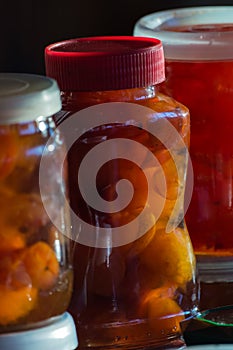 Glass jars with red lid with apple jam close-up. Home canning. Delicious dessert for tea. Cooking.