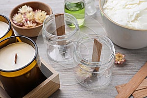 Glass jars with wooden wicks on light table. Making homemade candles