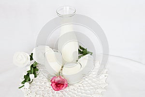 Glass jug and glass of milk sitting on white doily