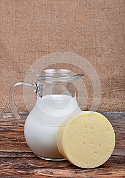 Glass jug with milk and cheese