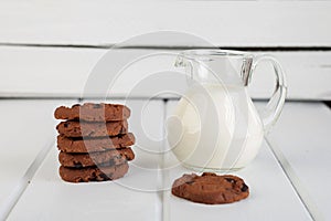 Glass jug with milk and chocolate chip cookies