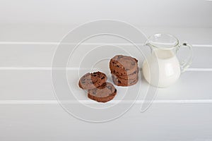 Glass jug with milk and chocolate chip cookies