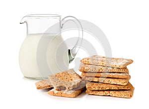 Glass jug with milk and cracker