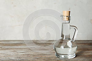 Glass jug with vinegar on table