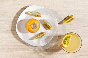 glass with juice and slices of lulo fruit, on the table