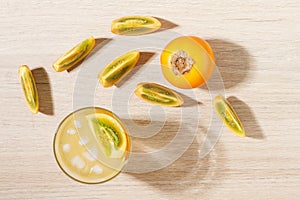 glass with juice and slices of lulo fruit, on the table