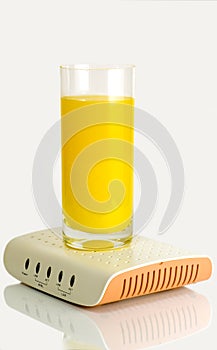 Glass of juice standing on computer modem