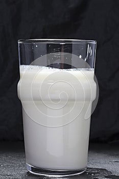 A glass of kefir on a black background photo
