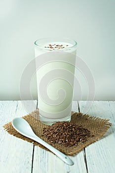 Glass of kefir with chopped flax seeds, on white. Concept of drinks for weight loss, diet.