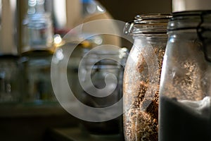 Glass Kilner jars full of provisions in a country kitchen pantry.